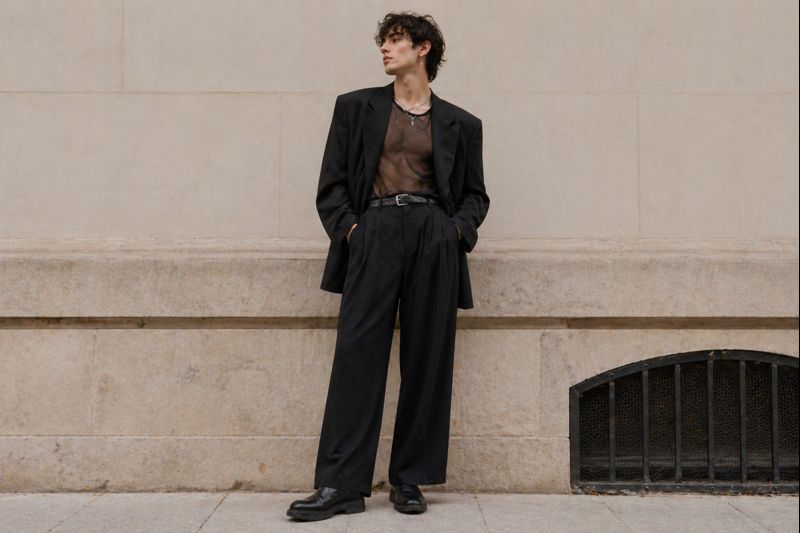 Tenue queer homme avec blazer oversize, pantalon large, top fluide et boots
